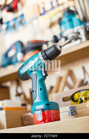 Trapano Cordless sul tavolo in un laboratorio di falegnameria o garage. Foto Stock
