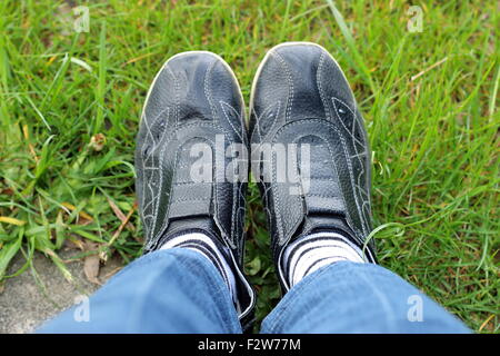 Colpo di sneakers nero con il bianco e nero a strisce calze sull'erba Foto Stock