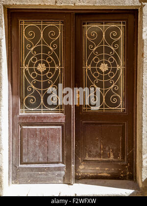 Un vecchio ragged shabby porta in legno con in ferro battuto Foto Stock