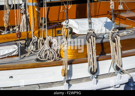 Deck, funi, armamento e pulegge in legno / blocchi a bordo della barca a vela / yacht Foto Stock