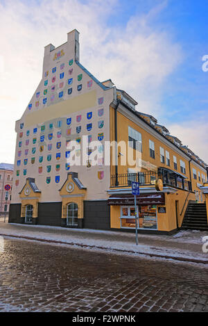 La parete esterna della casa con stemmi della città lettone a Riga, Lettonia Foto Stock