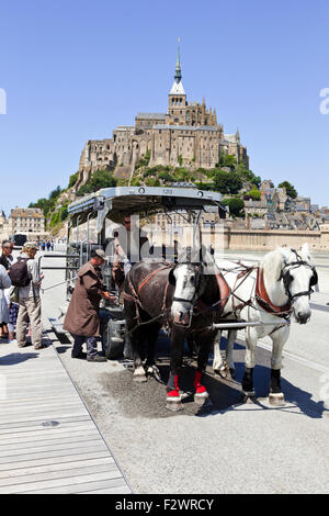 Una carrozza a cavallo di prendere i turisti da e per Mont Saint Michel, in Normandia, Francia - Mont St Michel Foto Stock