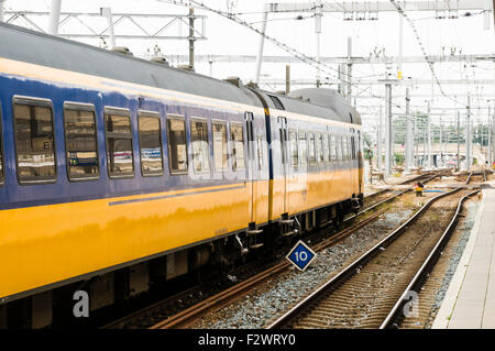 Il blu e il giallo treno in partenza Utrecht Centraal Station Foto Stock