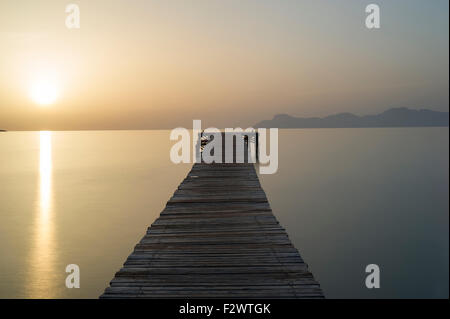 Pontile in legno a sunrise. Port d'Alcuida, Mallorca, Spagna Foto Stock