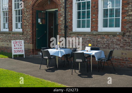 Sedie e tavoli (con un panno) istituito al di fuori Poppleton superiore village hall dove bevande vengono serviti - nessun cliente come ancora. Vicino a York, GB, UK. Foto Stock