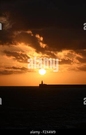 Il faro del porto di Newhaven sulla costa del Sussex in Inghilterra meridionale, in silhouette al tramonto. Foto Stock