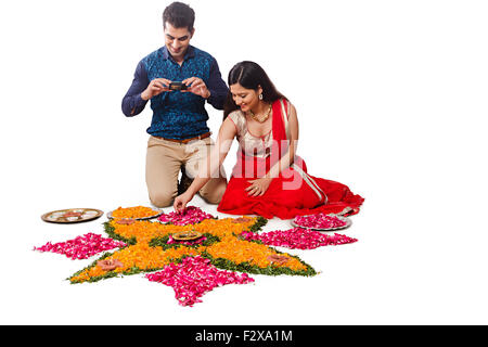 2 indian coppia sposata Diwali Festival Progettazione Rangoli e telecamera facendo clic su foto Foto Stock