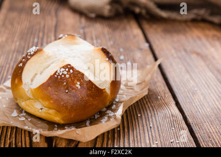 Il salato Pretzel rotolo (close-up shot) sul rustico sfondo di legno Foto Stock