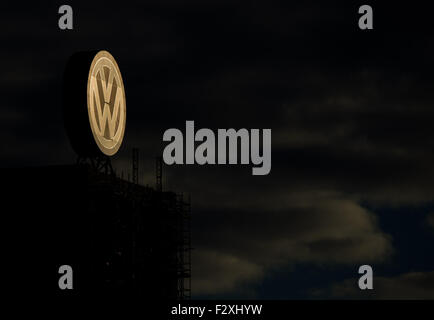 Un logo aziendale di Volkswagen illuminato dalla luce del mattino presso lo stabilimento della casa automobilistica tedesca a Wolfsburg, in Germania, il 25 settembre 2015. Foto: JULIAN STRATENSCHULTE/dpa Foto Stock