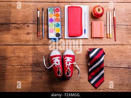 Scrivania con forniture scolastiche. Studio shot su sfondo di legno. Foto Stock