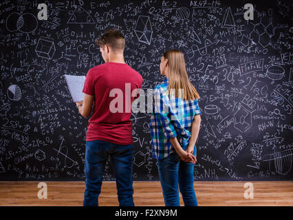 Giovane e bella studenti davanti a un grande lavagna Foto Stock