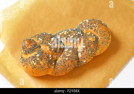 Pane appena sfornato bun con semi di papavero e sale sulla carta da forno Foto Stock
