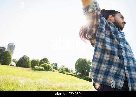 Un giovane uomo di lasciar giù la sua lunga capigliatura scura. Foto Stock