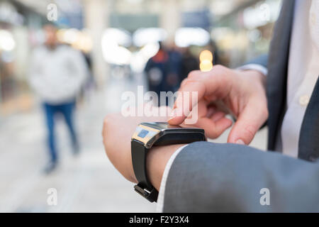 Nella postazione di sala di un uomo con il suo smartwatch. Close-up le mani Foto Stock