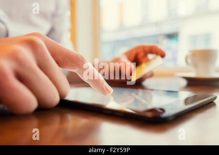 Uomo che utilizza un Tablet PC. Carta di credito, shopping online. Sfondo finestra Foto Stock