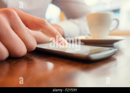 Uomo in un bar utilizzando il telefono cellulare. Filtro vintage Foto Stock
