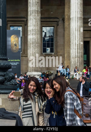 Le tre ragazze prendendo selfie davanti al British Museum di Londra, Inghilterra Foto Stock