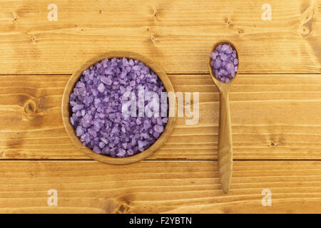 Mare di lavanda sale per bagno nel recipiente di bambù in marrone chiaro sfondo di legno Foto Stock