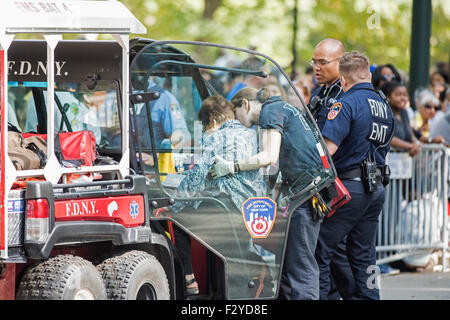 La città di New York, Stati Uniti. Xxv Sep, 2015. EMS (il servizio medico di emergenza) il personale ad aiutare le donne a superare dalla folla di Central Park. Papa Francesco e il suo corteo percorsa da East Harlem a Midtown Manhattan a titolo di Central Park dove migliaia di persone si erano raccolte per vedere lui di passaggio. Credito: Andy Katz/Pacific Press/Alamy Live News Foto Stock