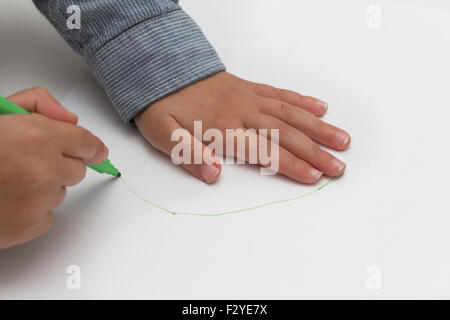 Bambino tenendo la penna sul foglio di carta bianco. kid disegna su carta bianca Foto Stock