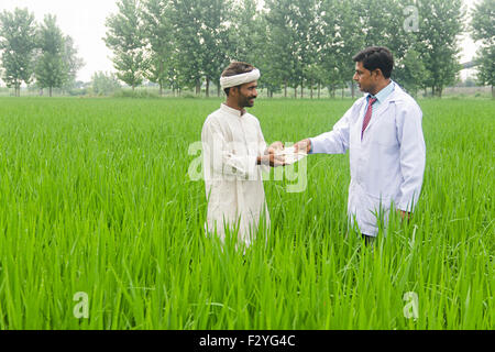 2 indian medico rurale e contadino Farm dando denaro Foto Stock