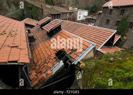 Dente di sega tetto,con piastrelle rotte, industriale wasteland, sito di fabbriche valle, nella città di Thiers, Auvergne Francia Europa. Foto Stock