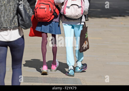 Londra, Inghilterra, Regno Unito. Donna con molto sottili gambe camminando con un amico Foto Stock