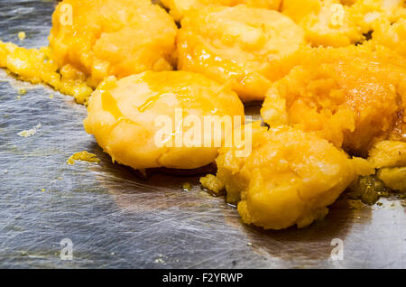 Tipico ecuadoriano torte di patate chiamato llapingachos con delizioso ripieno di formaggio cottura su una superficie metallica. Foto Stock