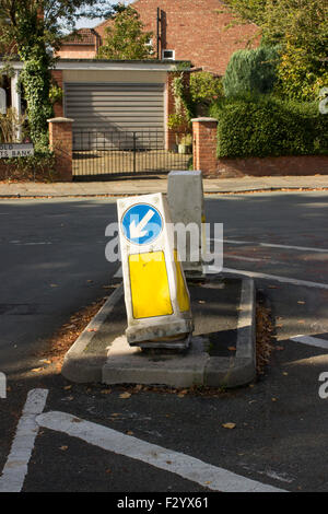 Traffico segno bollard in mezzo alla strada. La freccia rivolta a sinistra in bianco con sfondo blu. Foto Stock