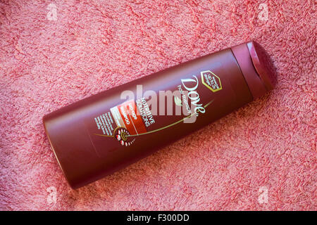 Bottiglia di Colomba terapia capelli soluzioni nutritive pro-age shampoo sul tovagliolo di rosa Foto Stock