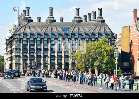 Portcullis House Londra ufficio complesso per il Regno Unito per i membri del Parlamento europeo con i turisti a piedi lungo Westminster Bridge marciapiede England Regno Unito Foto Stock