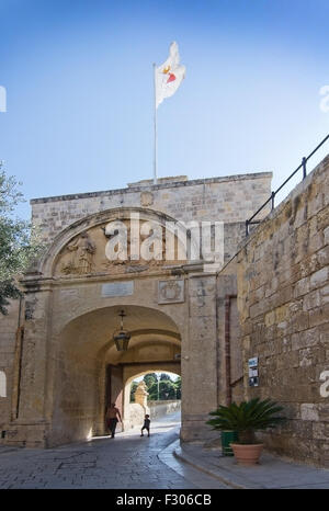 Uomo e ragazzo che entra attraverso l'ingresso ad arco il portale per la città silenziosa Mdina in una giornata di sole in settembre, Malta. Foto Stock