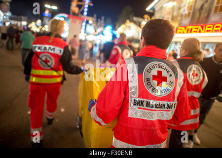 Monaco di Baviera, Germania. 23 Sep, 2015. I paramedici della Croce Rossa tedesca spingere una barella in una posizione in corrispondenza del 182nd Oktoberfest a Monaco di Baviera, Germania, il 23 settembre 2015. 8.000 pazienti sono stati trattati presso il pronto soccorso gestito dalla Croce Rossa tedesca lo scorso anno, con 680 di loro soffrono di avvelenamento da alcool. Il più grande del mondo del festival della birra che durerà fino al 04 ottobre 2015 sono attesi circa sei milioni di visitatori da tutto il mondo di quest'anno. Foto: Matthias esitano di fronte/dpa/Alamy Live News Foto Stock