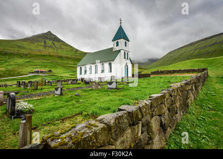 Piccolo villaggio chiesa con cimitero in Gjogv situato sulla punta nord-orientale dell'isola di Eysturoy, Isole Faerøer, Danimarca Foto Stock