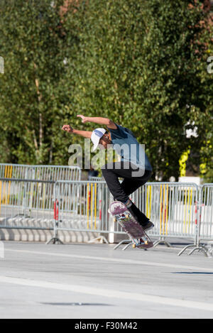 Un giovane ragazzo di eseguire trucchi sul suo skateboard in un parcheggio in Birmingham West Midlands, Regno Unito Foto Stock