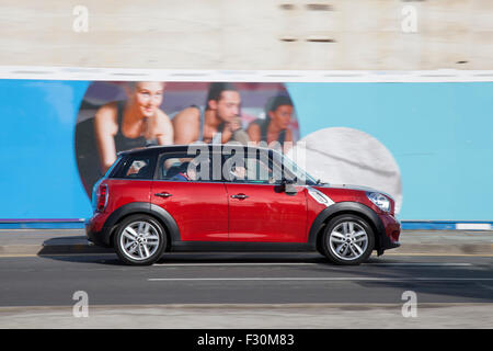 Mini berlina quattro porte auto vista laterale strada sfocata; le autostrade di Liverpool, Merseyside, Regno Unito. Traffico veicolare sulla Strand. Foto Stock