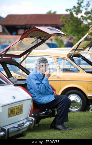 Wolverston, Milton Keynes, Regno Unito. Il 27 settembre, 2015. Immagine mostra Arthur croce (84) da Braintree gustando una tazza di tè nel retro della sua Austin Maxi 1500cc alla celebrazione annuale della British Leyland's classic cars in Milton Keynes, Buckinghamshire, UK. Credito: Jeff Gilbert/Alamy Live News Foto Stock