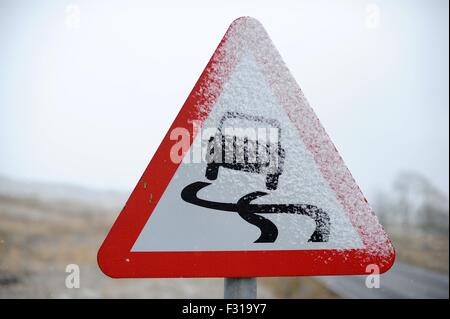 Un cartello stradale coperto di neve avvertenza car drivers di pericolose condizioni di guida. Foto Stock