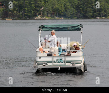 Pontoon deck barca con amici di famiglia persone a bordo. Lungo il lago di New York STATI UNITI D'AMERICA US America Adirondack State Park Foto Stock