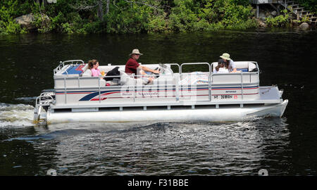 Pontoon deck barca con amici di famiglia persone a bordo. Lungo il lago di New York STATI UNITI D'AMERICA US America Adirondack State Park Foto Stock