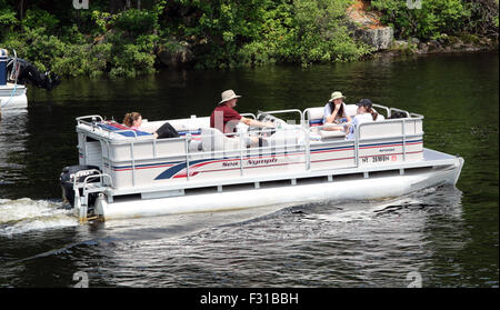 Pontoon deck barca con amici di famiglia persone a bordo. Lungo il lago di New York STATI UNITI D'AMERICA US America Adirondack State Park Foto Stock