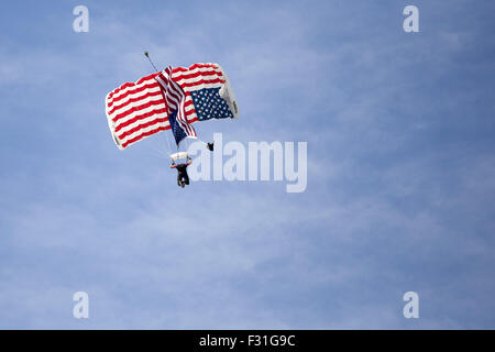 Millington, Tennessee, Stati Uniti d'America. Il 27 settembre, 2015. Come inno nazionale viene eseguita, un membro del Lucas Oil Team salto scivola attraverso l'aria con la sua bandiera-coperto paracadute. Domenica la performance ha segnato la fine del 2015 Airshow di Memphis a Millington Regional Jetport. © Raffe Lazarian/ZUMA filo/Alamy Live News Foto Stock