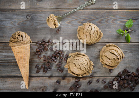 Vista superiore mocha gelato in cono di cialda e chicchi di caffè sul vecchio rustico in legno vintage background. Foto Stock