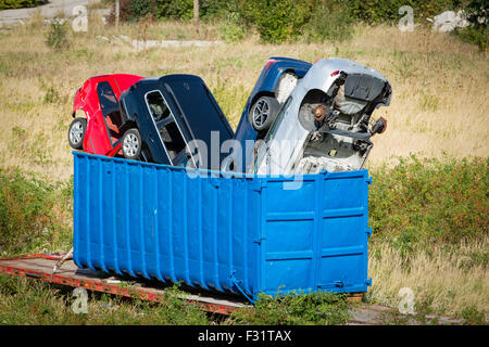 Vetture disastrate impilati in un contenitore blu Foto Stock