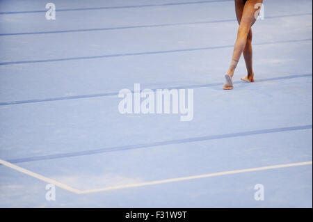 Piedi del ginnasta sono visibili sul pavimento esercizio durante il concorso di ginnastica Foto Stock