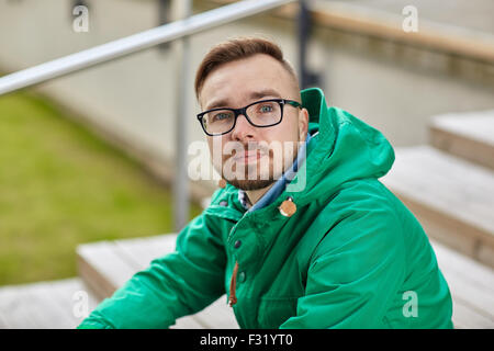 Felice tanga giovane uomo seduto sulle scale in città Foto Stock