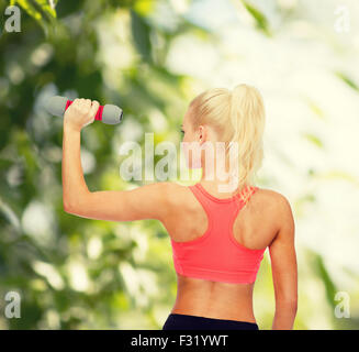 Giovane donna sportivo con luce dumbbell Foto Stock