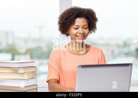 Felice americano africano donna con il portatile a casa Foto Stock