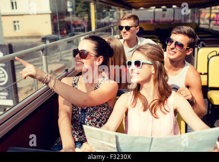 Gruppo di amici sorridenti che viaggiano in tour bus Foto Stock