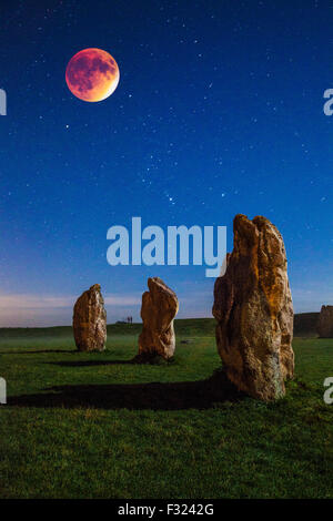 La luna di sangue oltre il sarsen le pietre a Avebury nel Wiltshire, Inghilterra, Regno Unito. Foto Stock